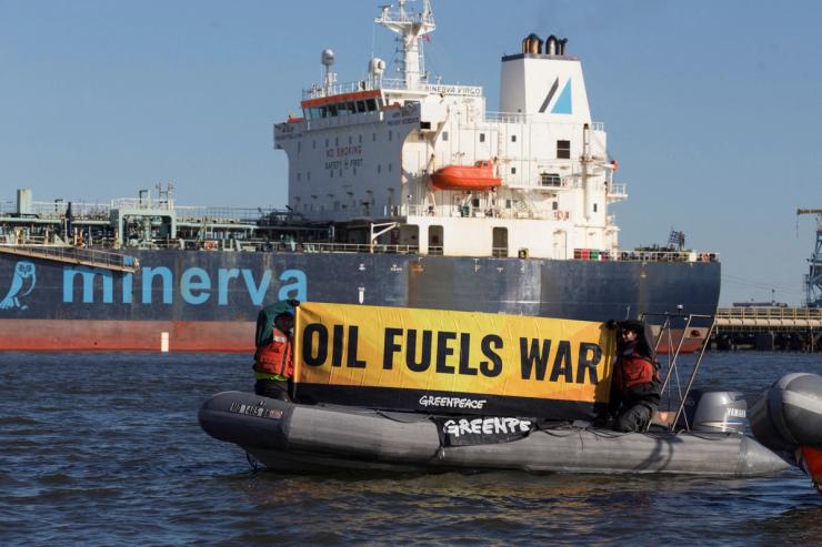Greenpeace activists protesting near an oil tanker.