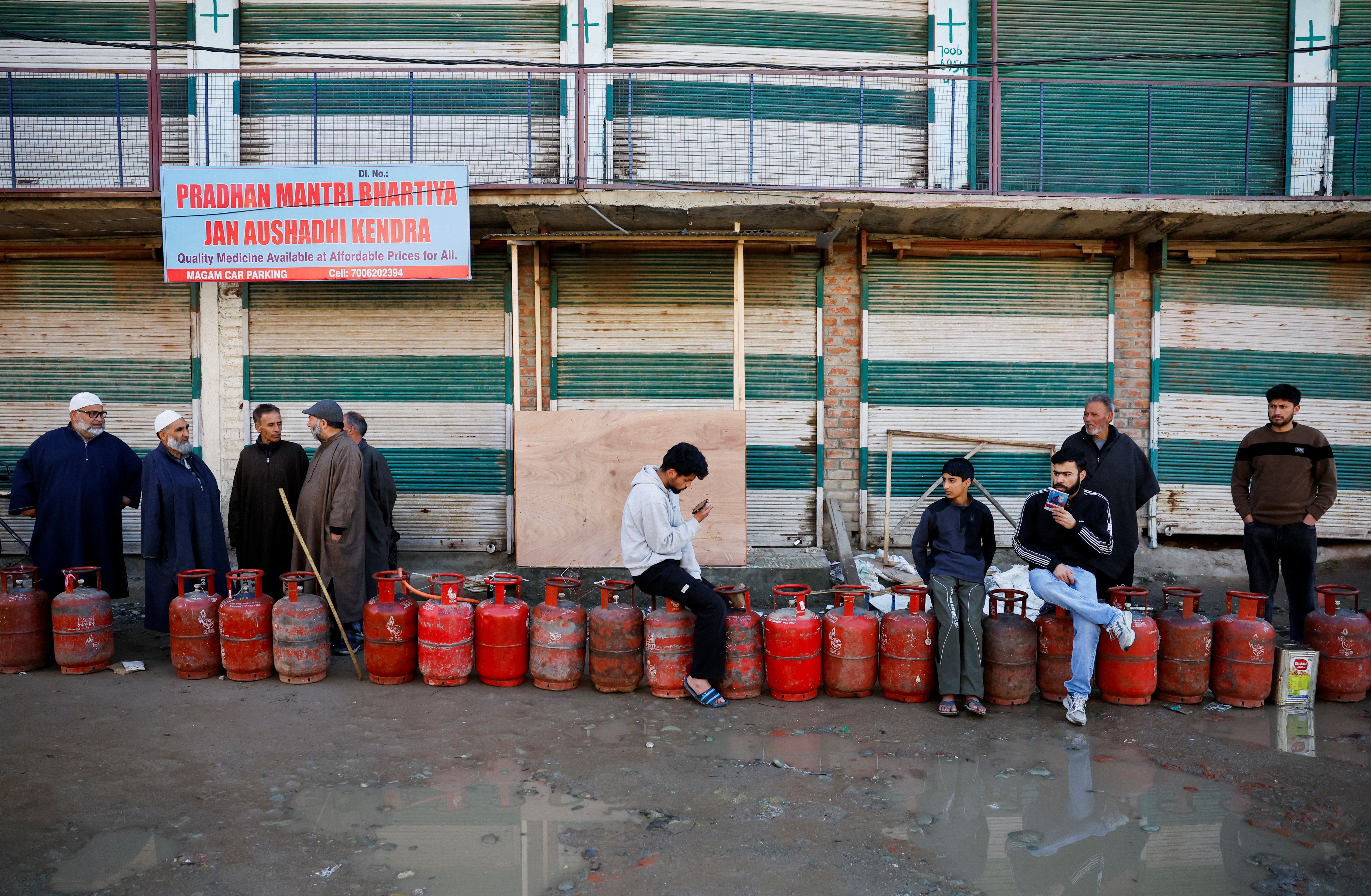 People wait in a queue with their empty LPG cylinders outside a gas agency amid supply disruptions following the U.S.-Israeli conflict with Iran, in Magam town, Indian Kashmir