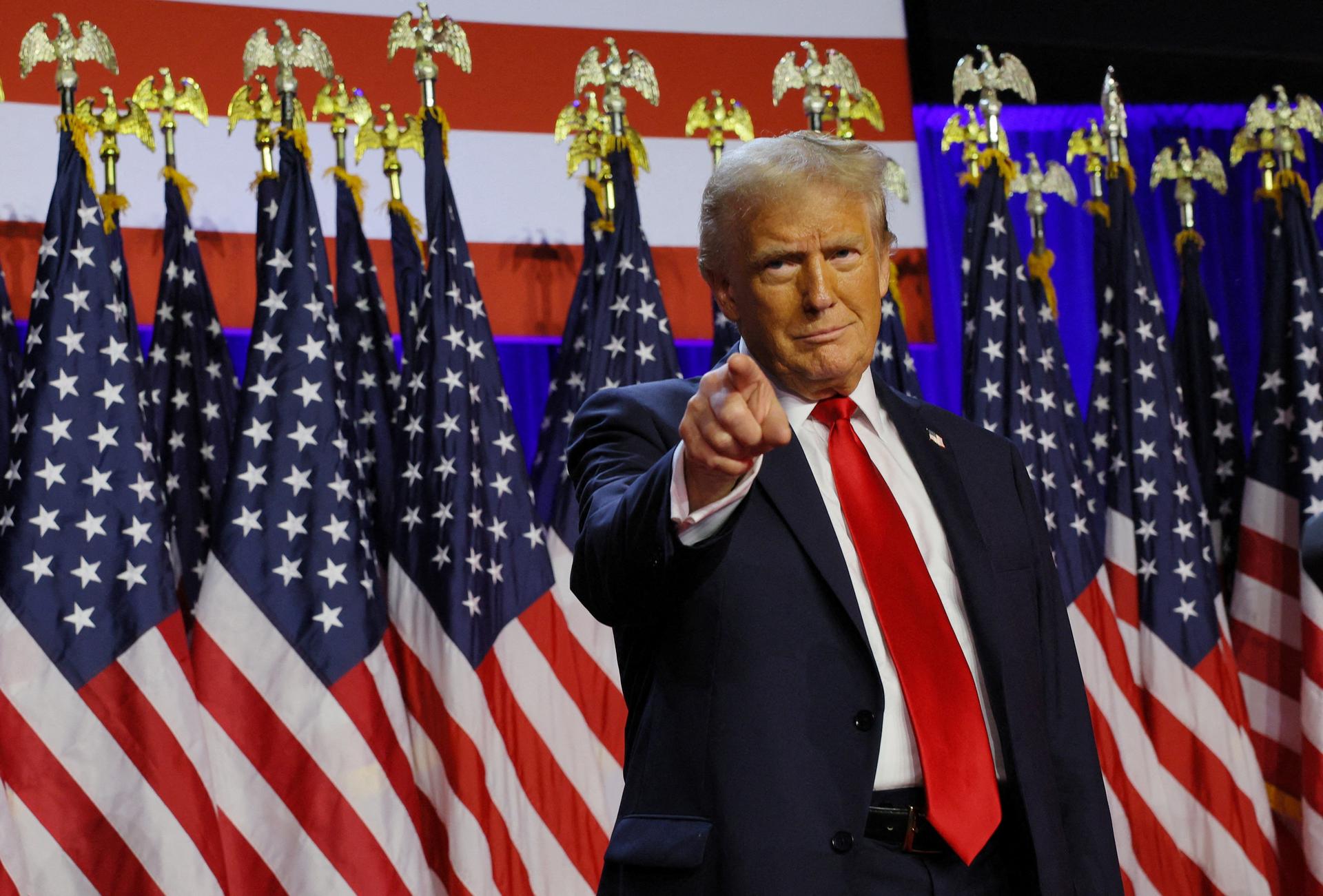 Donald Trump points towards the camera on stage at his the Palm Beach County Convention Center in Florida.