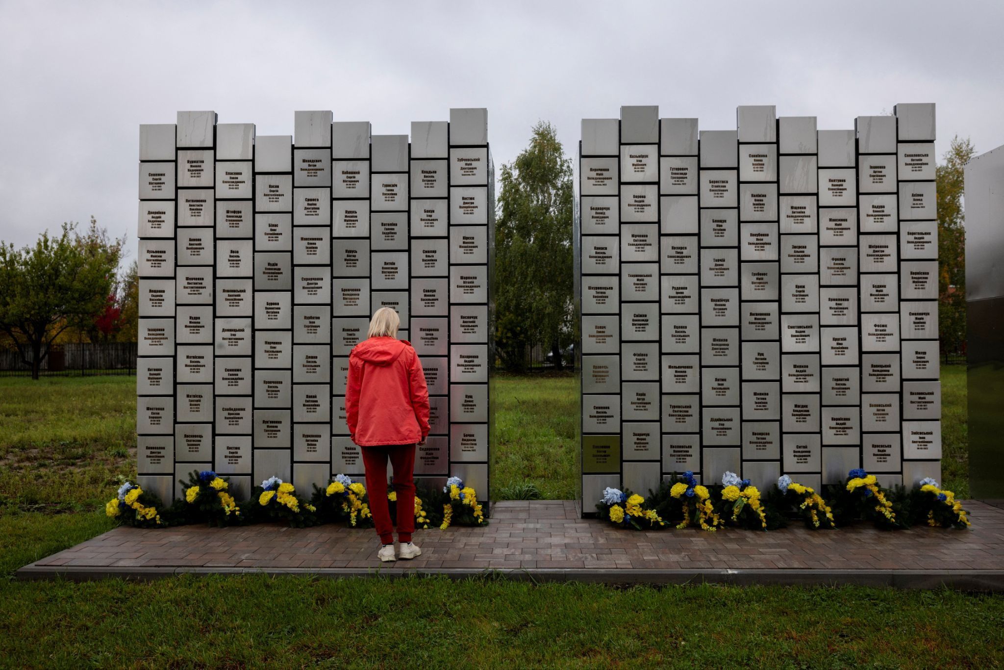 A Ukrainian woman visits a memorial in Bucha