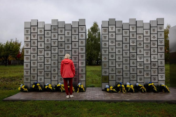 A Ukrainian woman visits a memorial in Bucha