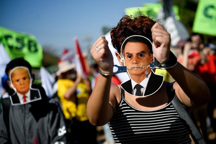 A demonstrator wearing a mask depicting Brazilian former President Jair Bolsonaro, gestures in handcuffs during a protest against U.S. President Donald Trump’s tariffs on Brazilian products
