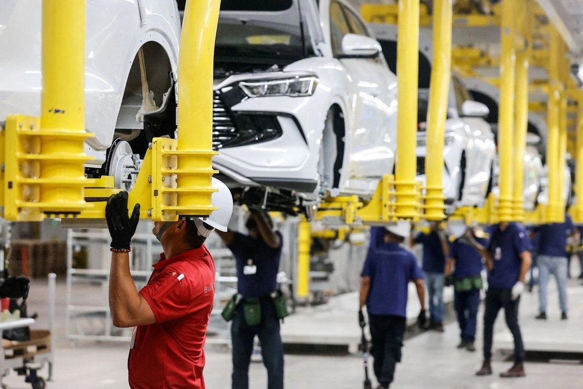 Workers assembling EVs at a factory.