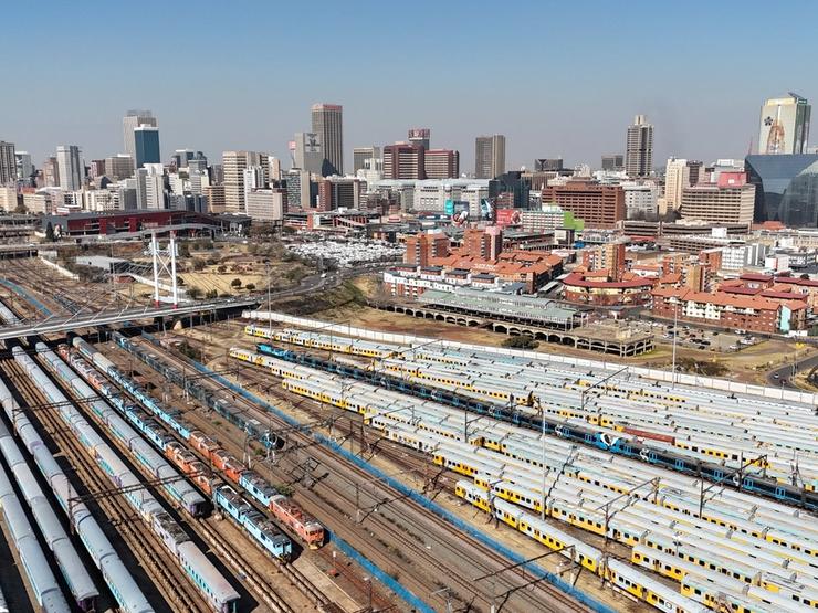 Trains parked beneath the Nelson Mandela Bridge with part of the city of Johannesburg