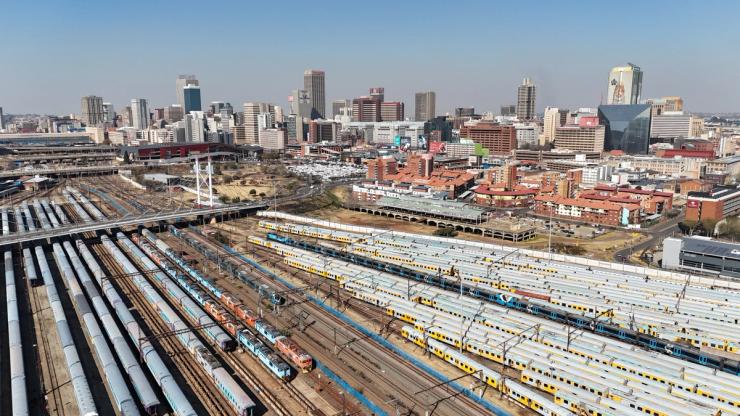 Trains parked beneath the Nelson Mandela Bridge with part of the city of Johannesburg