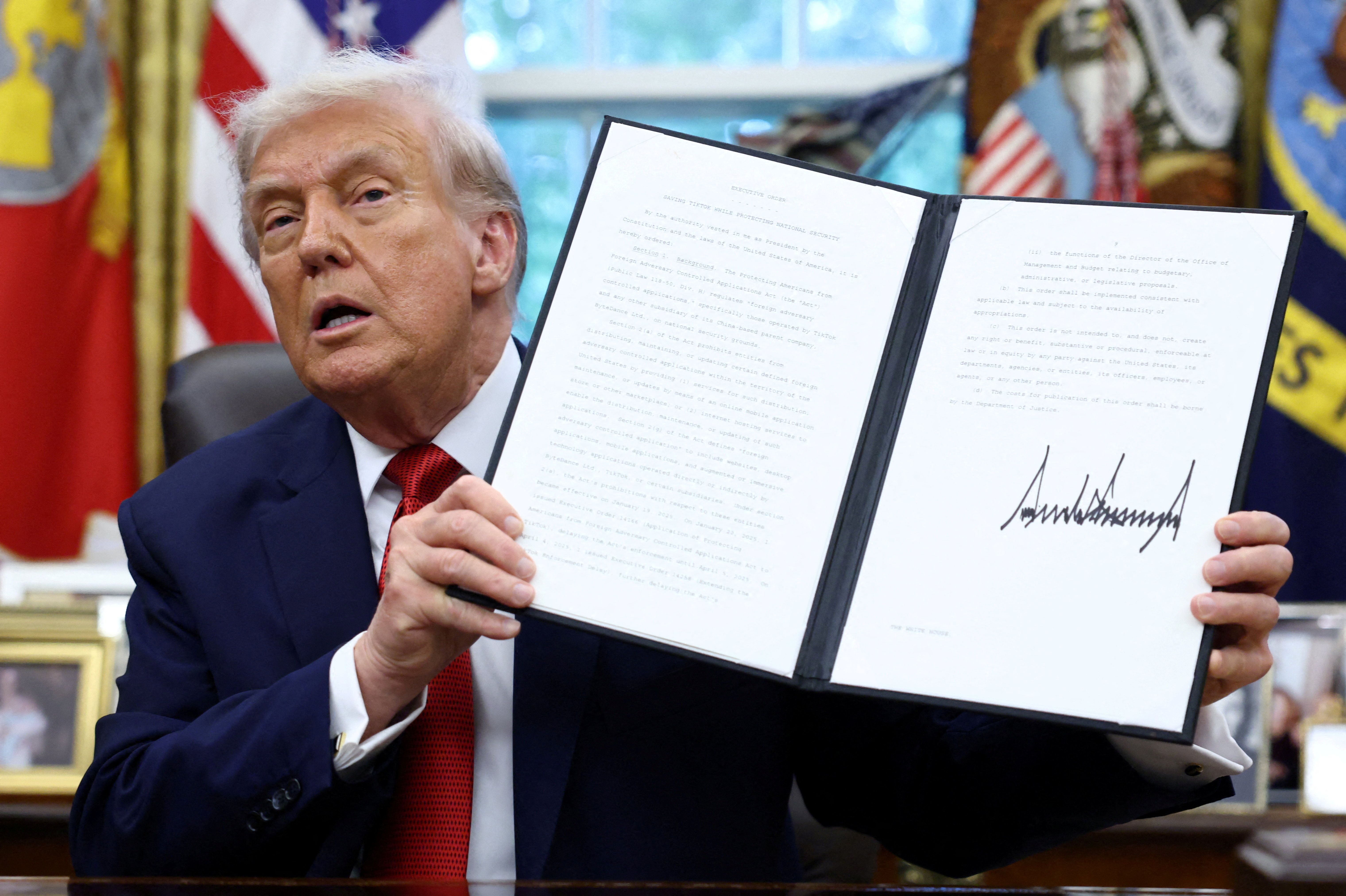 President Trump displays a signed executive order.