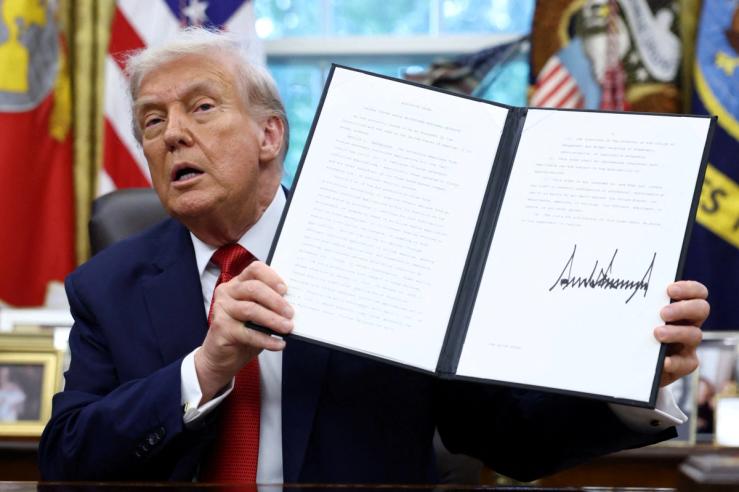 President Trump displays a signed executive order.