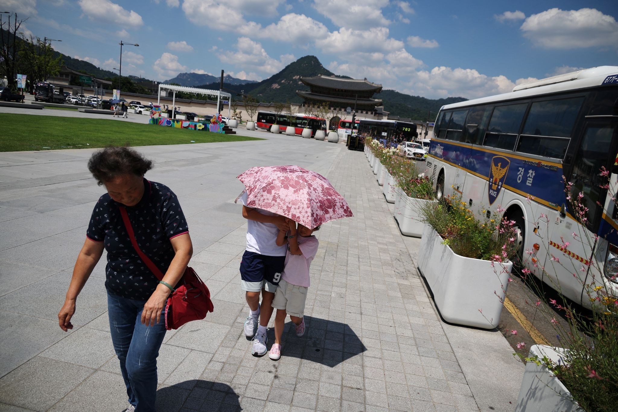 Children holding an umbrella to protect themselves from strong sun rays in central Seoul. 