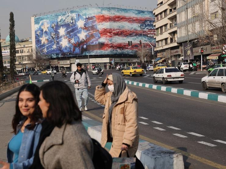 People walk past an anti-U.S. billboard in Tehran, Iran
