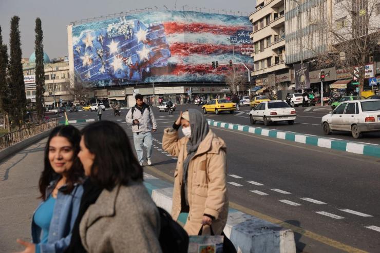 People walk past an anti-U.S. billboard in Tehran, Iran