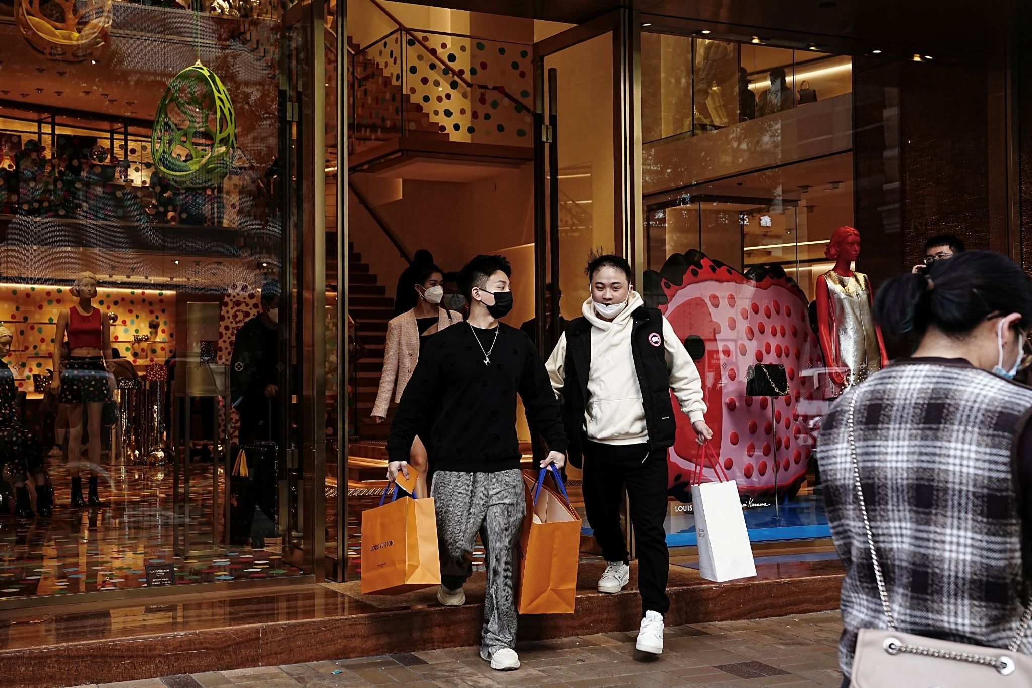 Shoppers walk out of a luxury store at Tsim Sha Tsui district in Hong Kong, China
