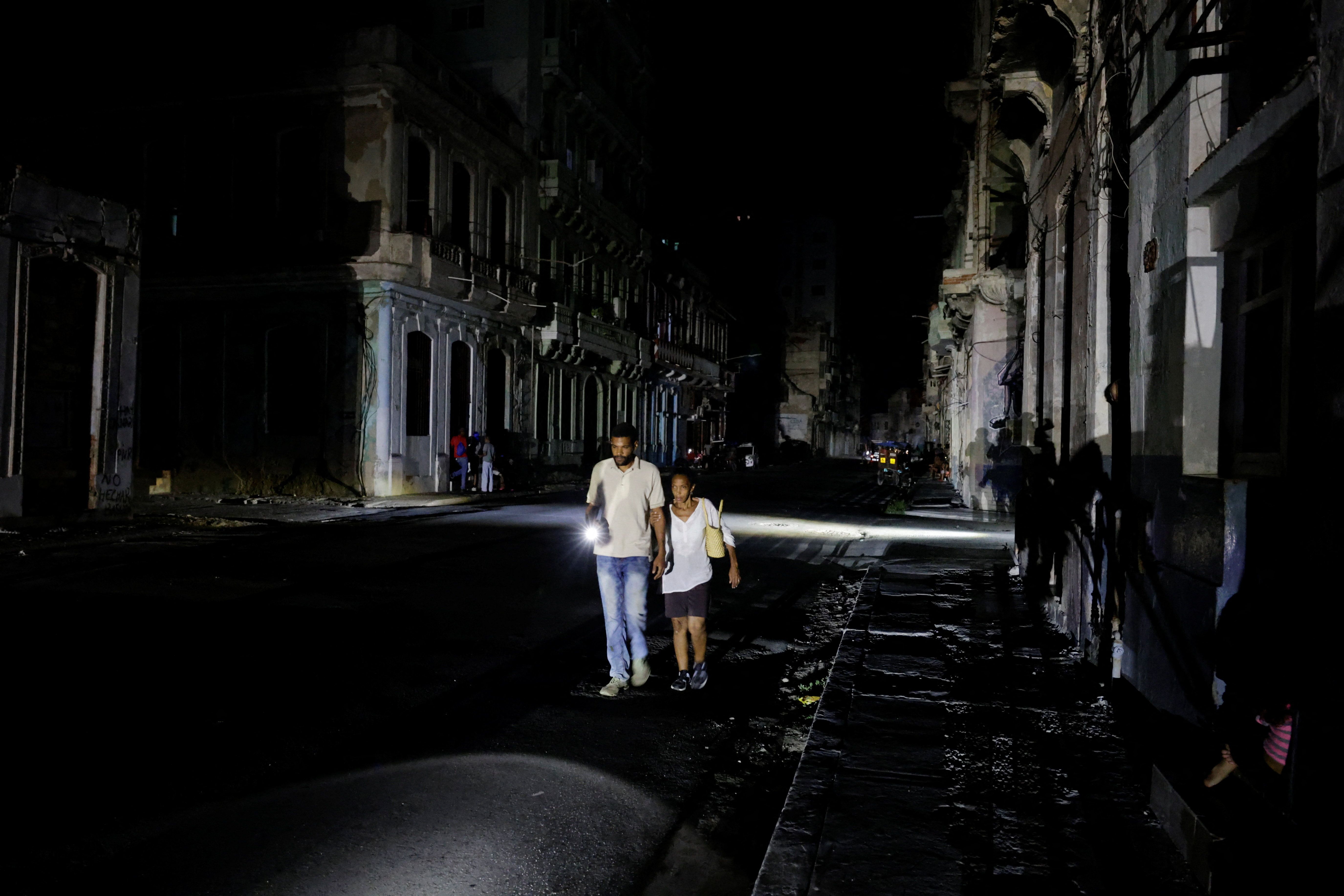 People walk down a street as Cuba’s national power grid collapsed.