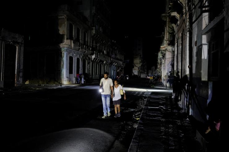 People walk down a street as Cuba’s national power grid collapsed.