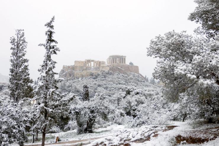 A view of the Parthenon temple atop the Acropolis hill during snowfall in Athens, Greece, February 6, 2023.