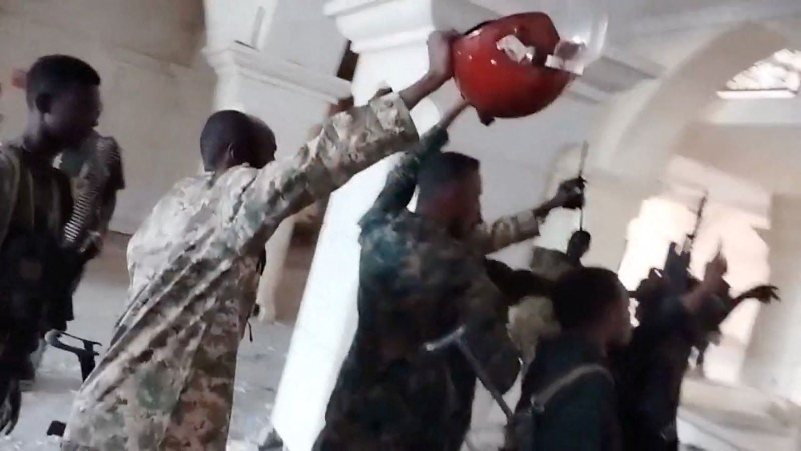 Sudanese army members celebrate inside the presidential palace