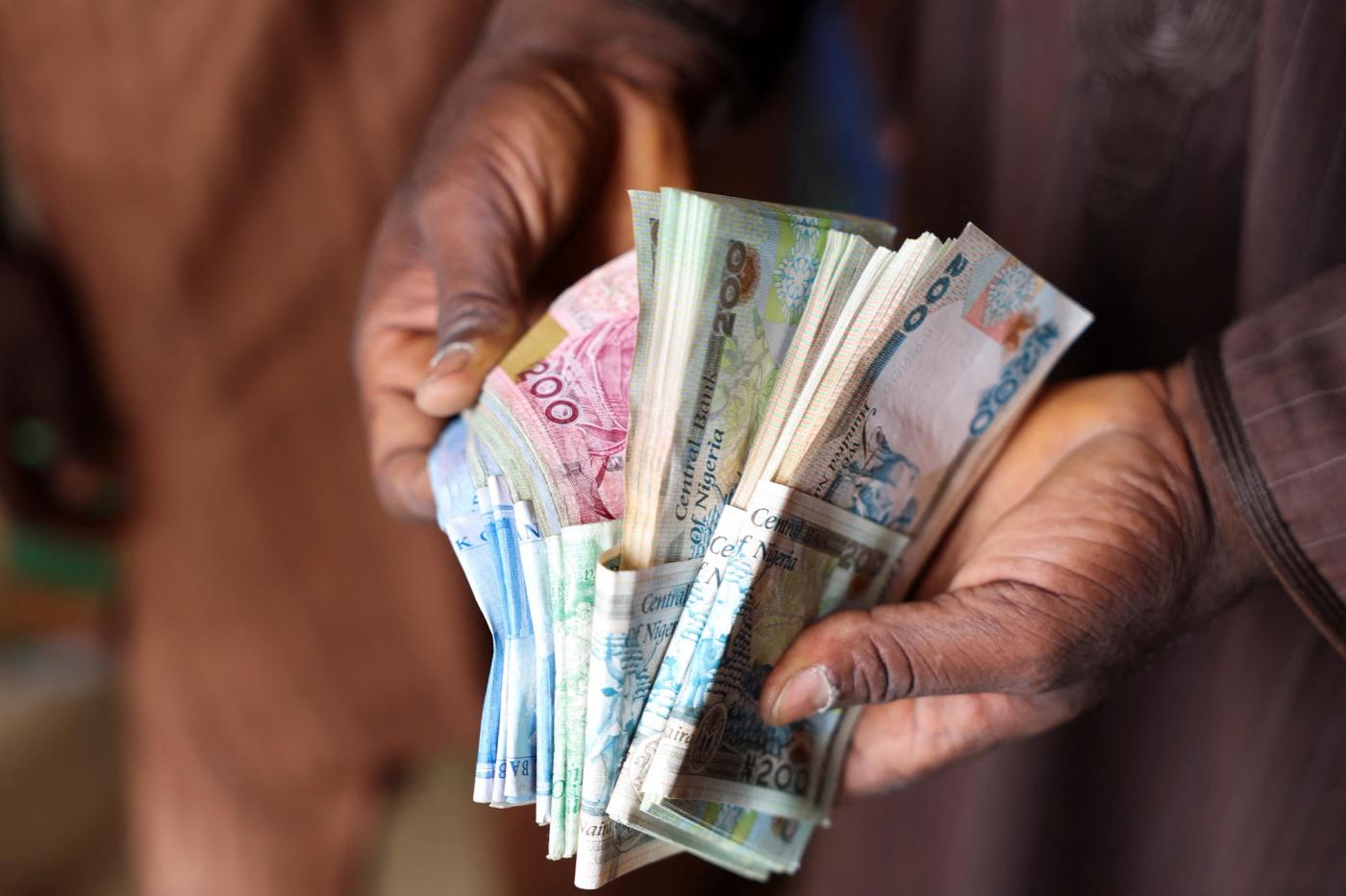 A man counts Nigerian naira notes in a market place as people struggle with the economic hardship and cashflow problems ahead of Nigeria's Presidential elections, in Yola, Nigeria, February 22, 2023.