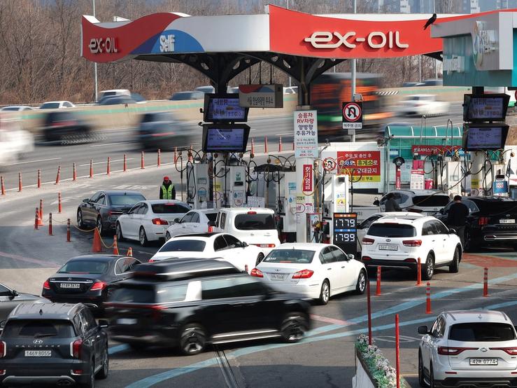 People fill up their car at a gas station in Seoul.