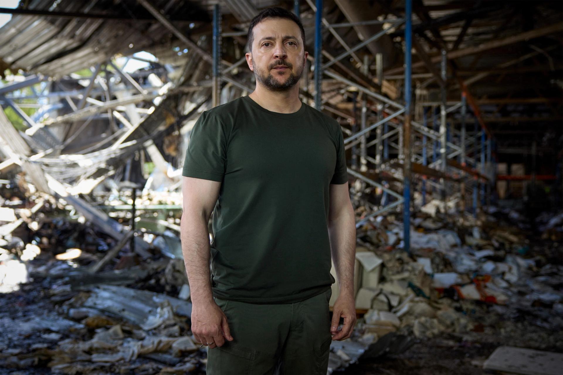 Ukrainian President Volodymyr Zelenskiy stands inside a printworks compound, destroyed on Thursday in a Russian airstrike, during his appeal to U.S. President Joe Biden and Chinese President Xi Jinping to join an upcoming peace summit, amid Russia's attack on Ukraine, in Kyiv, Ukraine May 26, 2024. Ukrainian Presidential Press Service/Handout via REUTERS
