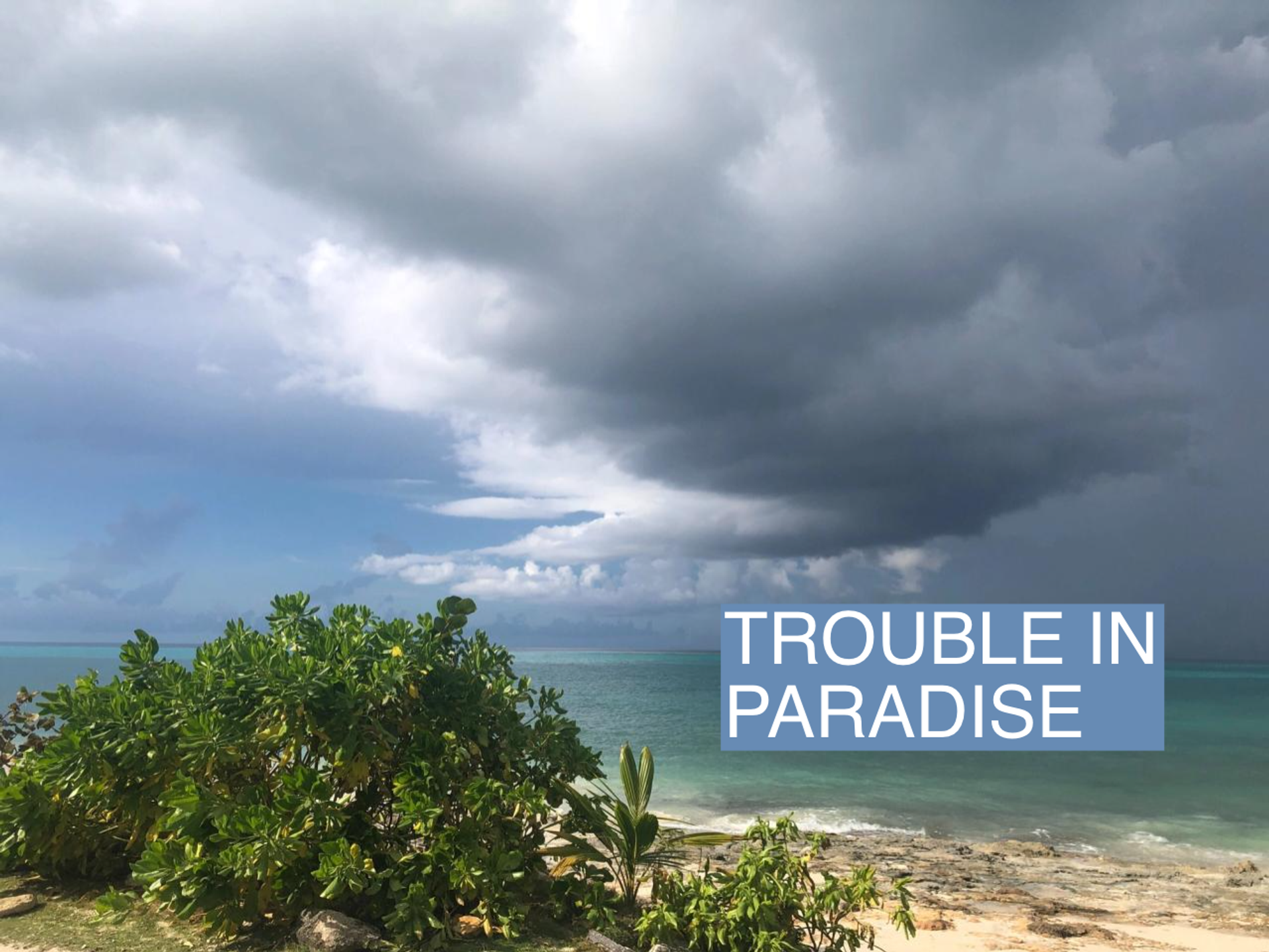 A storm cloud hangs over a beach in the Bahamas