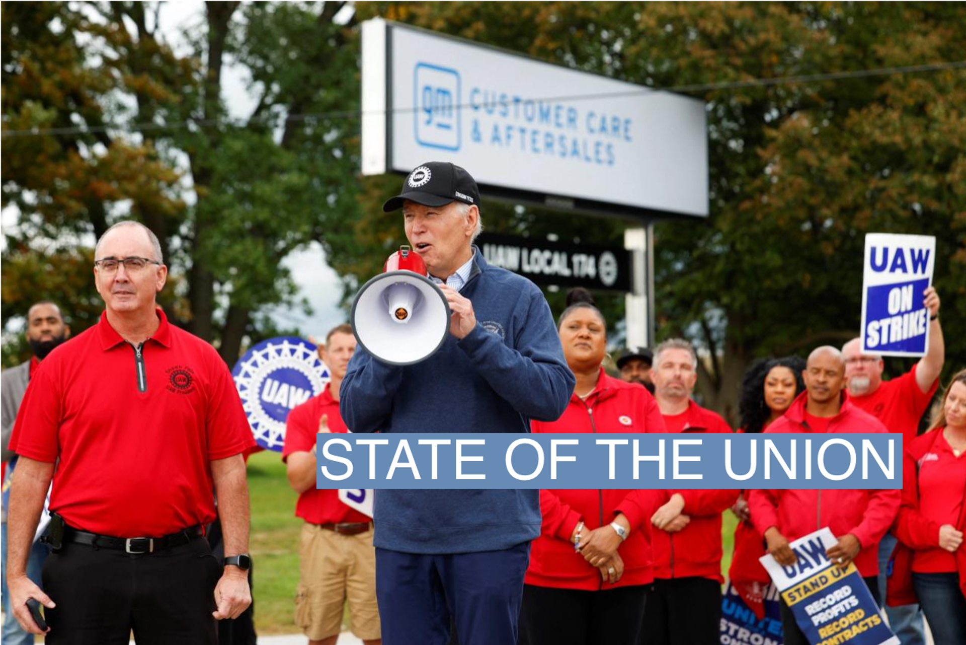 U.S. President Joe Biden speaks next to Shawn Fain, President of the United Auto Workers (UAW), as he joins striking members of the United Auto Workers (UAW) on the picket line outside the GM's Willow Run Distribution Center, in Bellville, Wayne County, Michigan, U.S., September 26, 2023. 