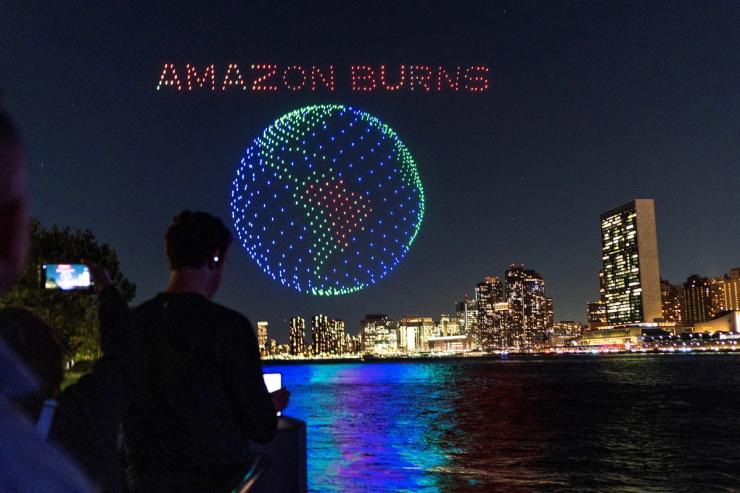 People watch drones creating a 3-D display outside the United Nations Headquarters calling attention to the Amazon rainforest and climate change in New York U.S., September 15, 2023. REUTERS/Eduardo Munoz TPX IMAGES OF THE DAY