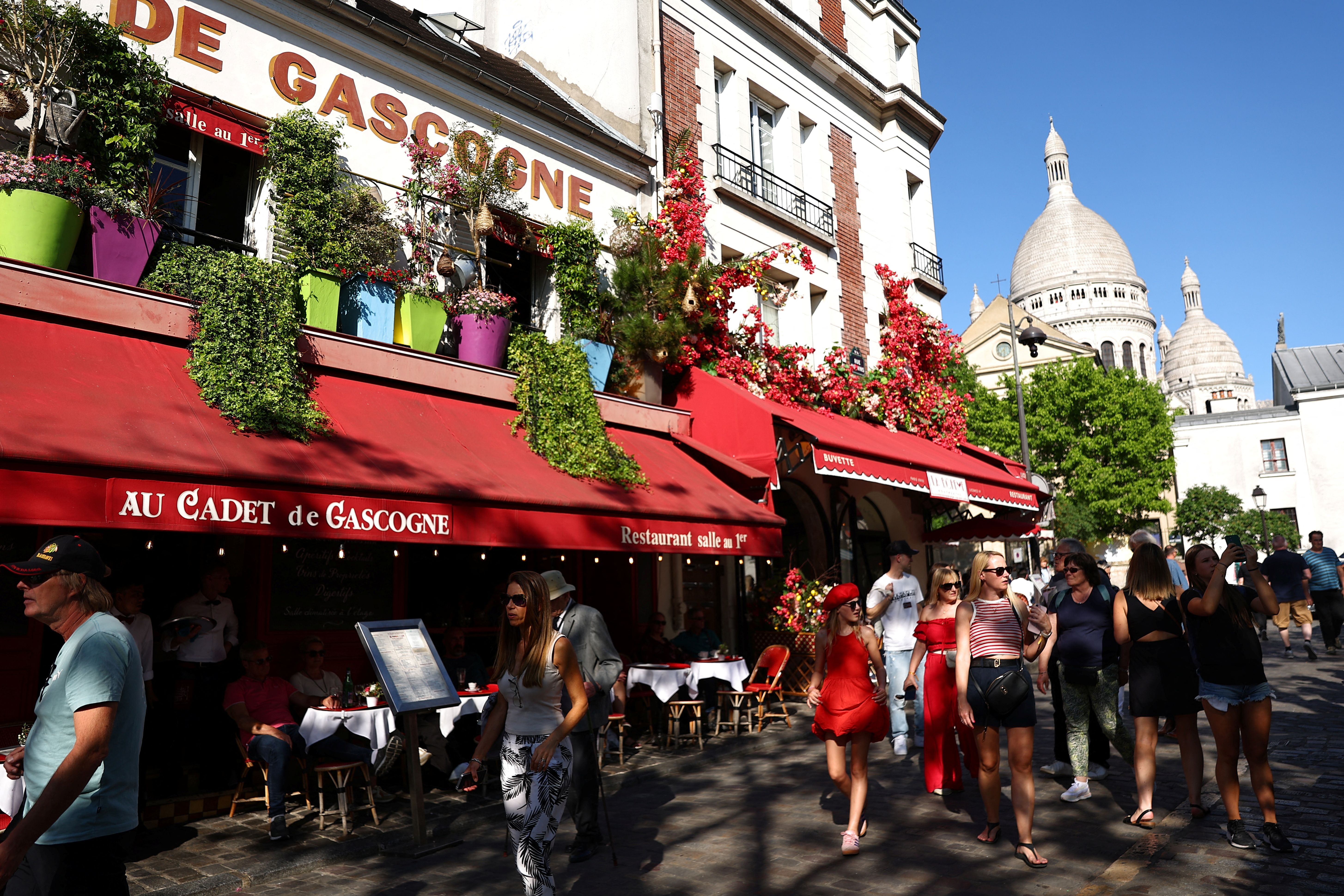 Tourists walk past the restaurant Au Cadet de Gascogne in Paris.