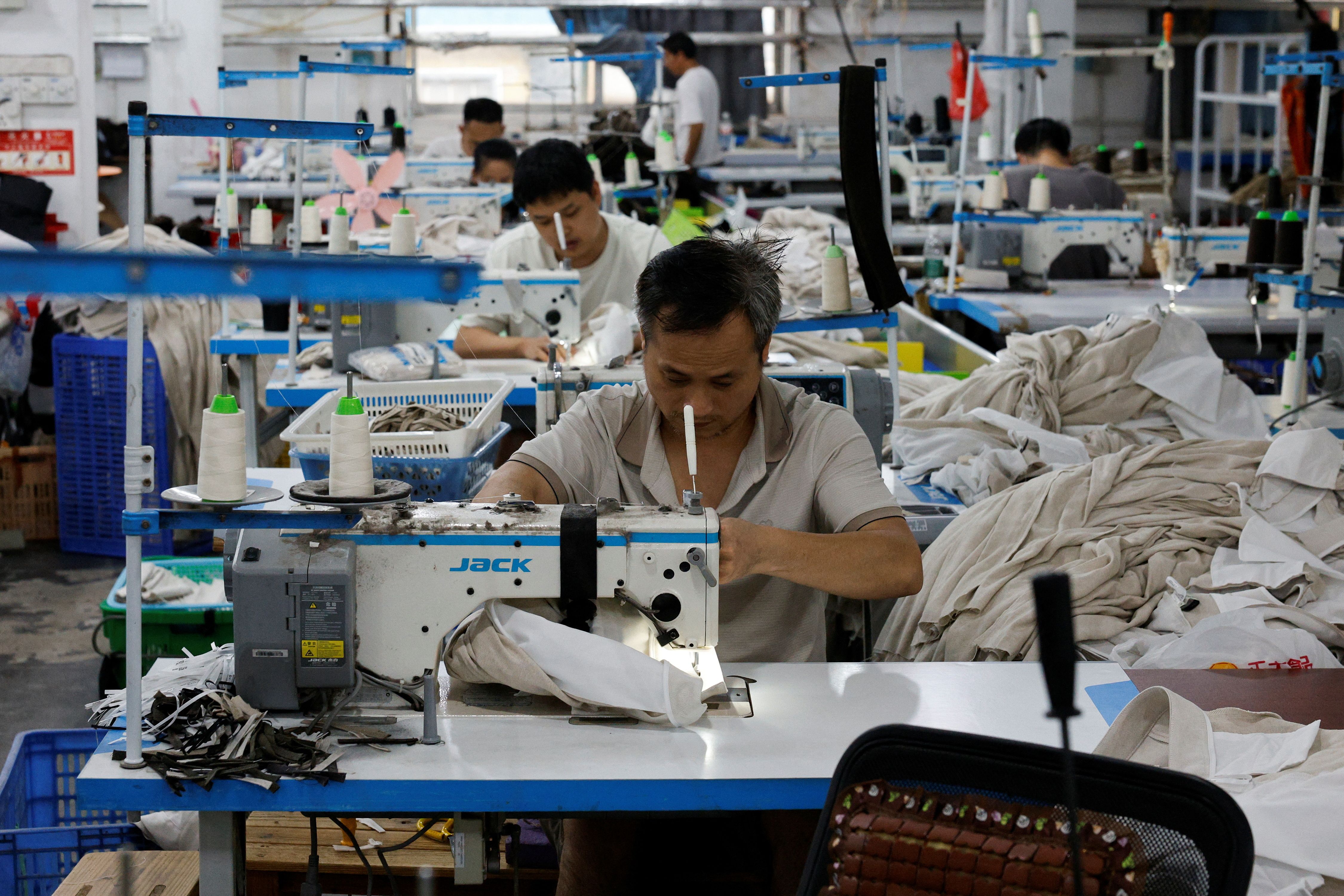 Employees work on a production line at a garment factory in Panyu District, Guangzhou.