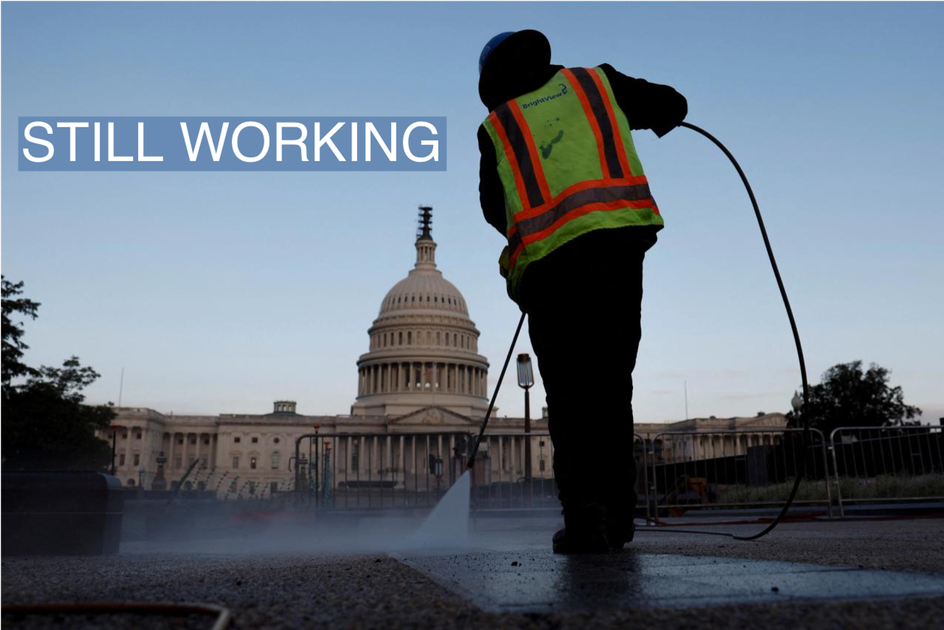 A worker cleans the sidewalk on the grounds of the U.S. Capitol.
