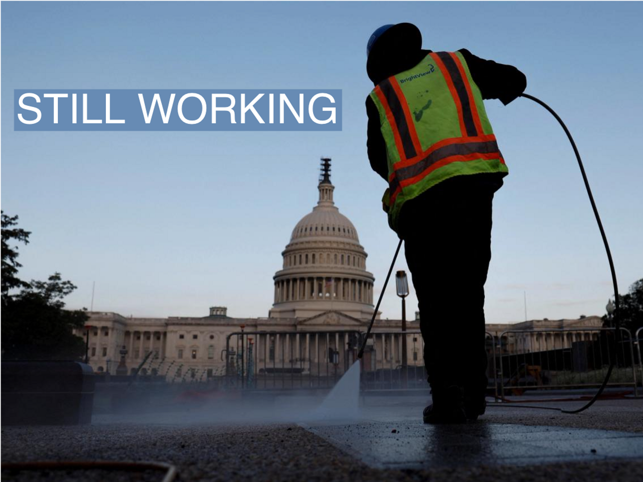 A worker cleans the sidewalk on the grounds of the U.S. Capitol.