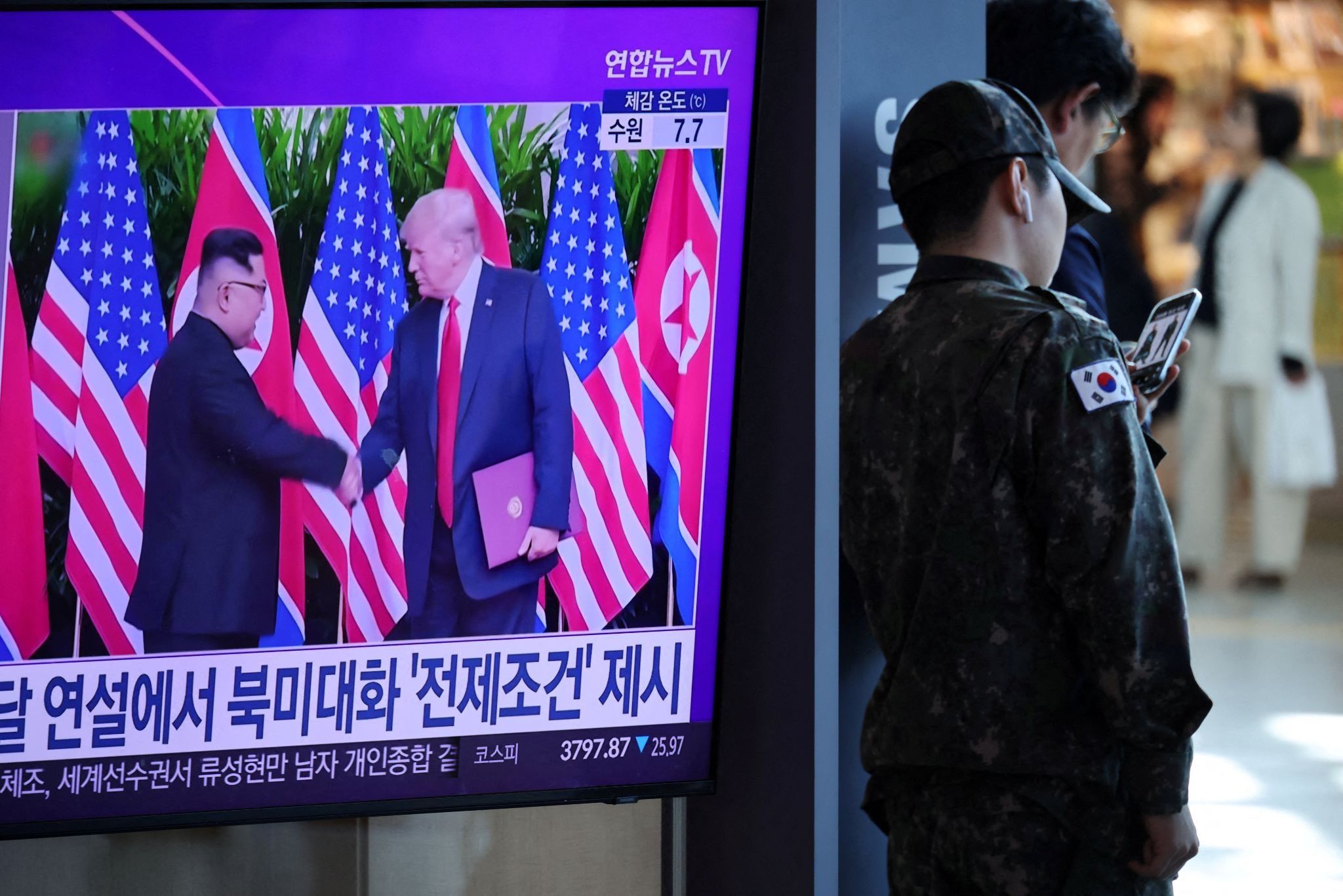 US President Donald Trump shakes hands with North Korean Leader Kim Jong Un on TV