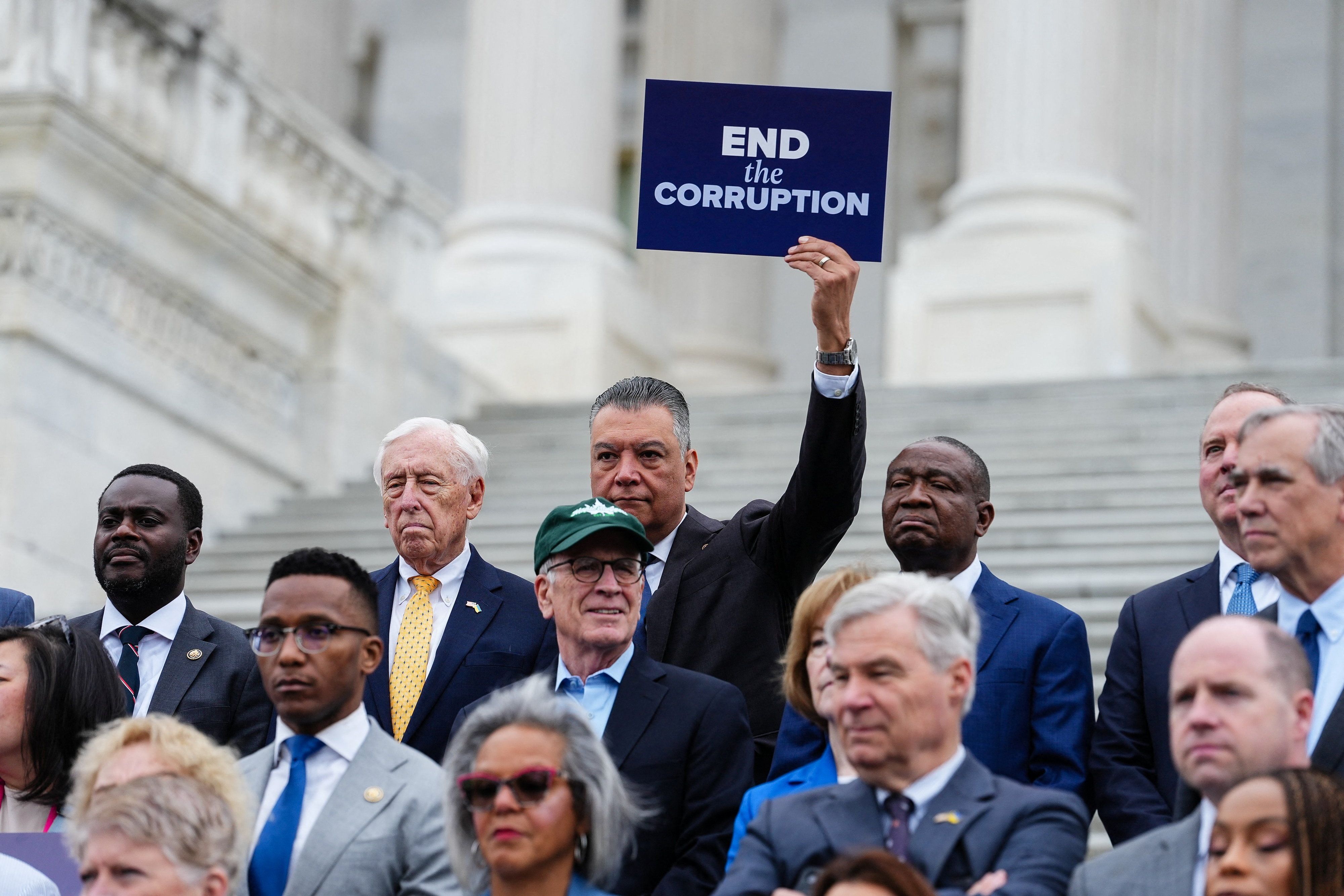 U.S. Senator Alex Padilla (D-CA) holds a sign reading, “End the Corruption” during a news conference ahead of voting on the Senate immigration funding bill on Capitol Hill in Washington, D.C., U.S.
