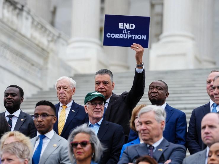 U.S. Senator Alex Padilla (D-CA) holds a sign reading, “End the Corruption” during a news conference ahead of voting on the Senate immigration funding bill on Capitol Hill in Washington, D.C., U.S.
