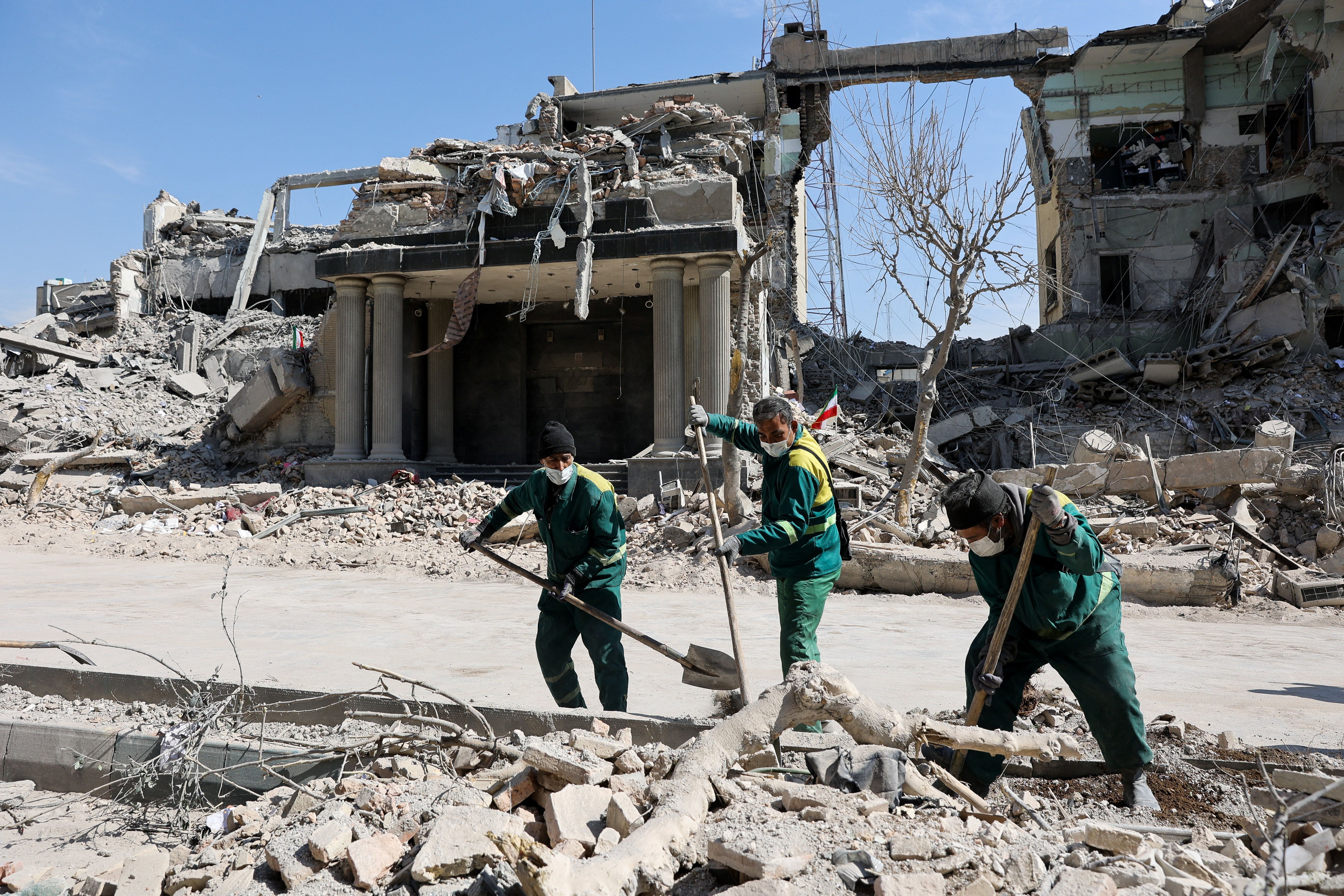 People clear out the rubble from a street following a strike on a police station, amid the U.S.-Israeli conflict with Iran, in Tehran, Iran.