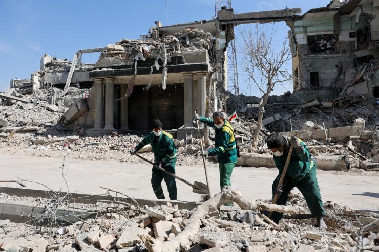 People clear out the rubble from a street following a strike on a police station, amid the U.S.-Israeli conflict with Iran, in Tehran, Iran.