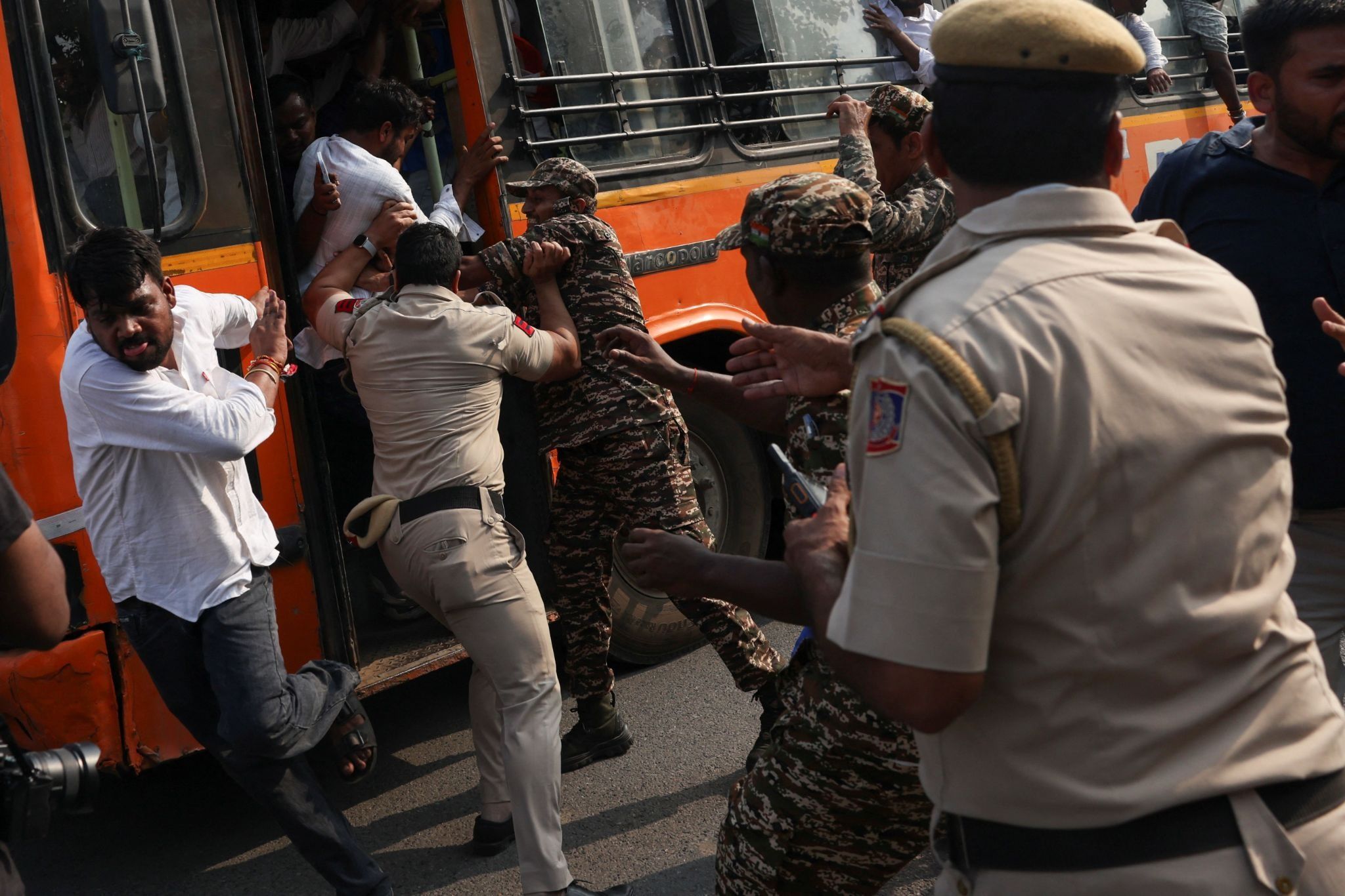 Security personalled tried to prevent detained protestsers from escapring a bus during a protest demanding the resignation of India’s chief election commissioner. 