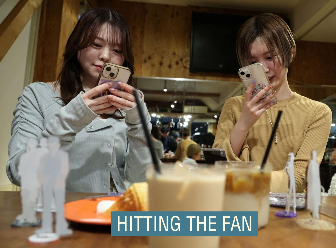 Two people in Japan with figures of their favorite idols. 