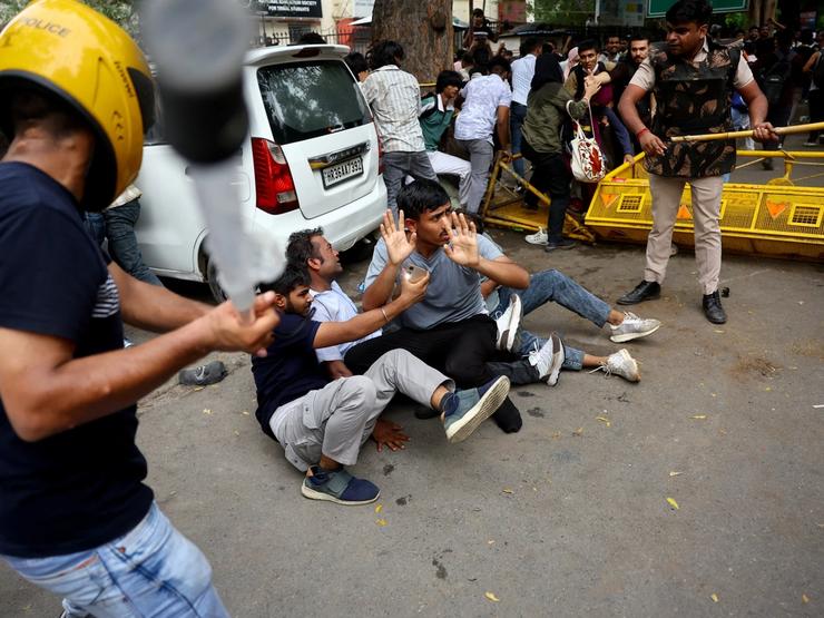 Security force personnel wield batons against demonstrators at a protest site during a planned march by supporters of India’s Cockroach Janta Party.