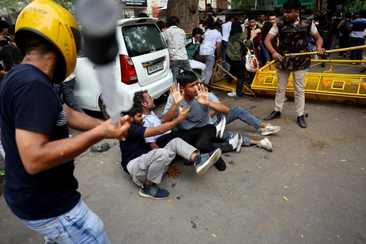 Security force personnel wield batons against demonstrators at a protest site during a planned march by supporters of India’s Cockroach Janta Party.