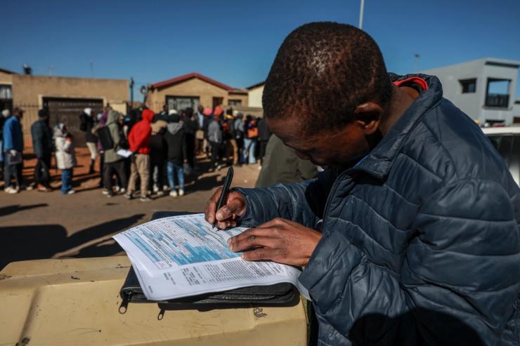 An unemployed youth fills in the Department of Unemployment and Labour work seeking registration form.