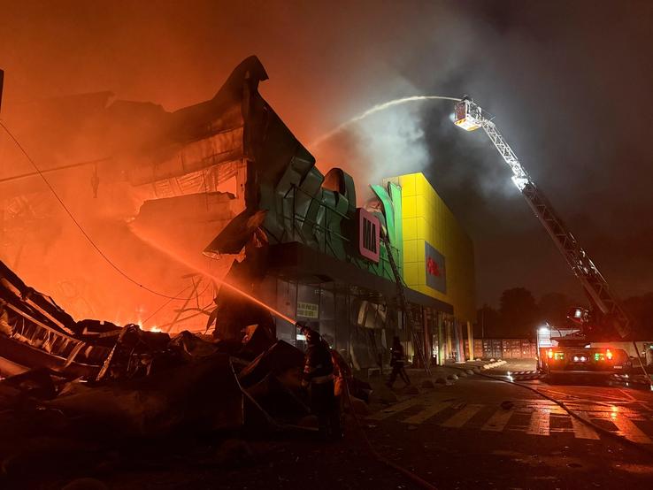 Firefighters work at the site of a shopping centre hit by a Russian missile attack in Kyiv.