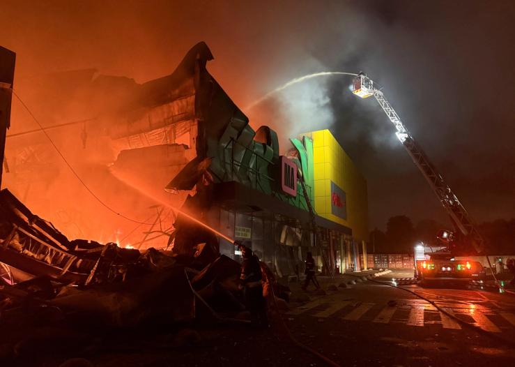 Firefighters work at the site of a shopping centre hit by a Russian missile attack in Kyiv.