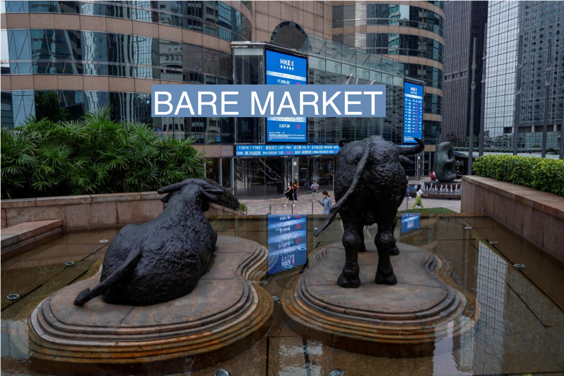 Bull statues are placed in font of screens showing the Hang Seng stock index and stock prices outside Exchange Square in Hong Kong. 