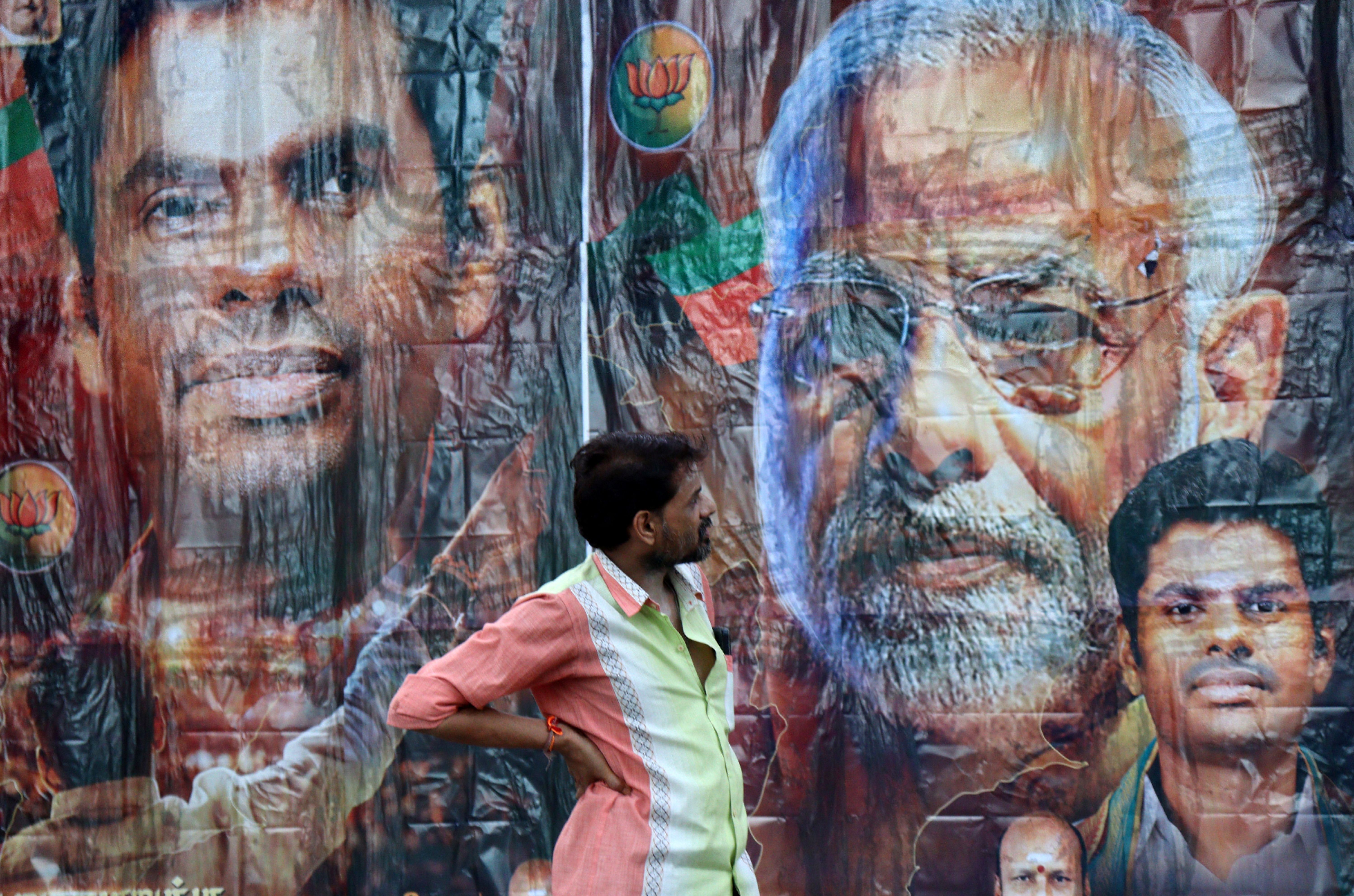 A man stands in front of a poster featuring India’s Prime Minister Narendra Modi and Bharatiya Janata Party (BJP) election candidate K. Annamalai, outside its party office in Chennai, India, June 4, 2024. REUTERS/Riya Mariyam R