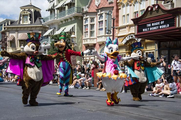 Disney film characters wave to park guest during the Festival of Fantasy parade at the Magic Kingdom Park at Walt Disney World in Orange County, Florida