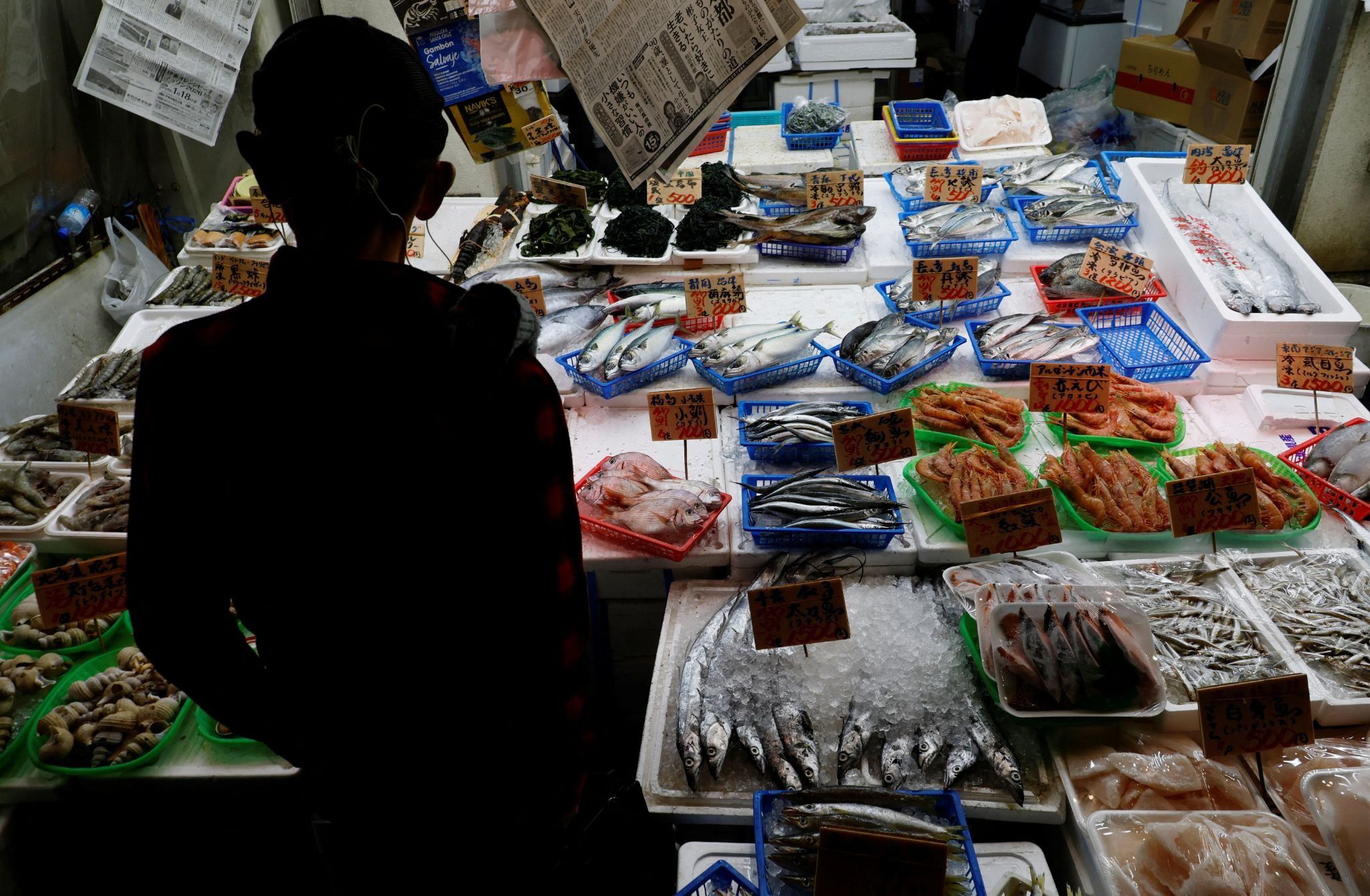 A customer looks around seafood at a shop in Tokyo