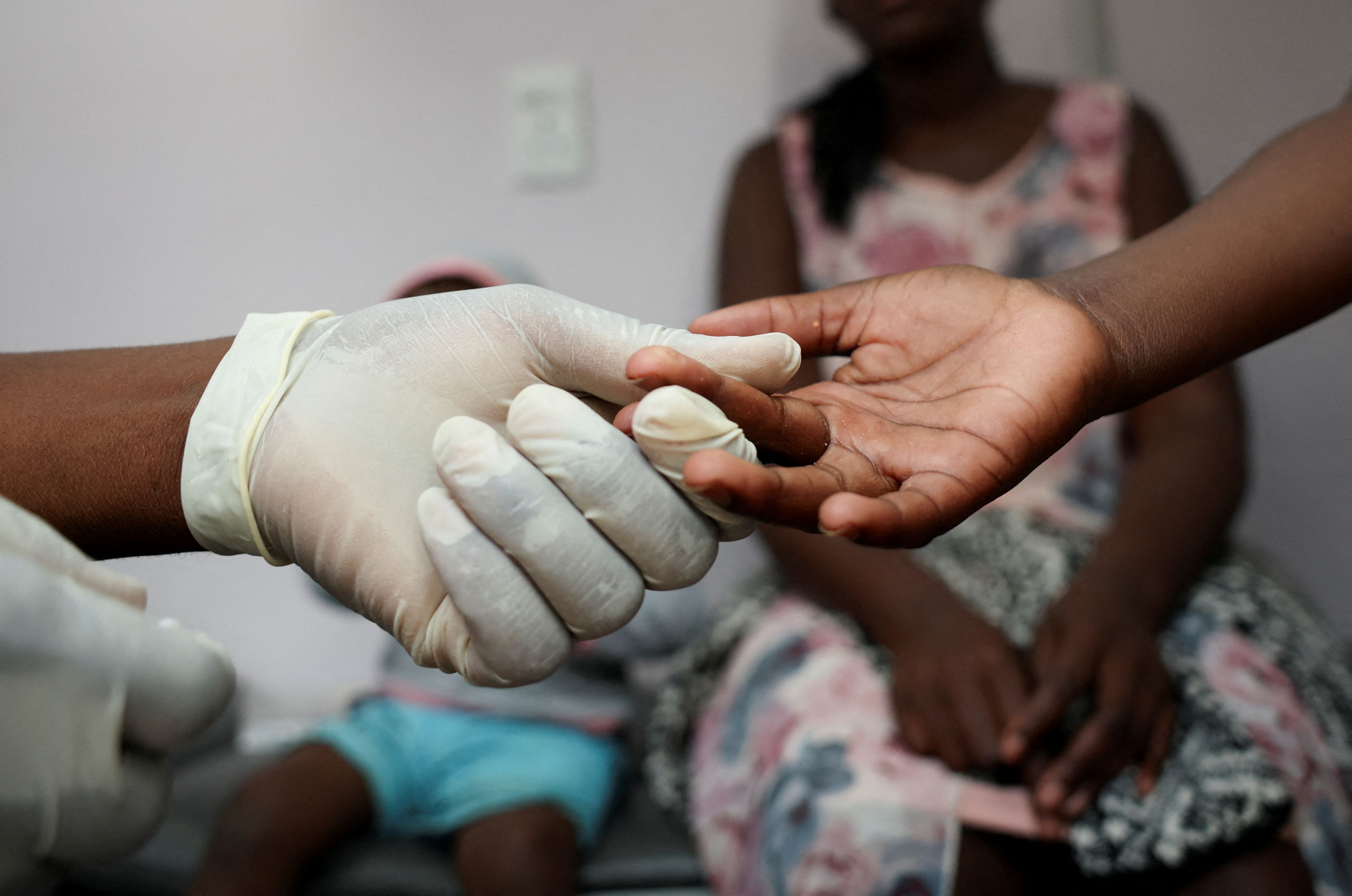 A nurse takes a blood sample from a child for an HIV test.