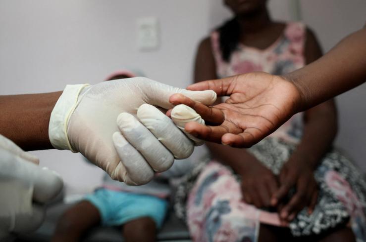 A nurse takes a blood sample from a child for an HIV test.