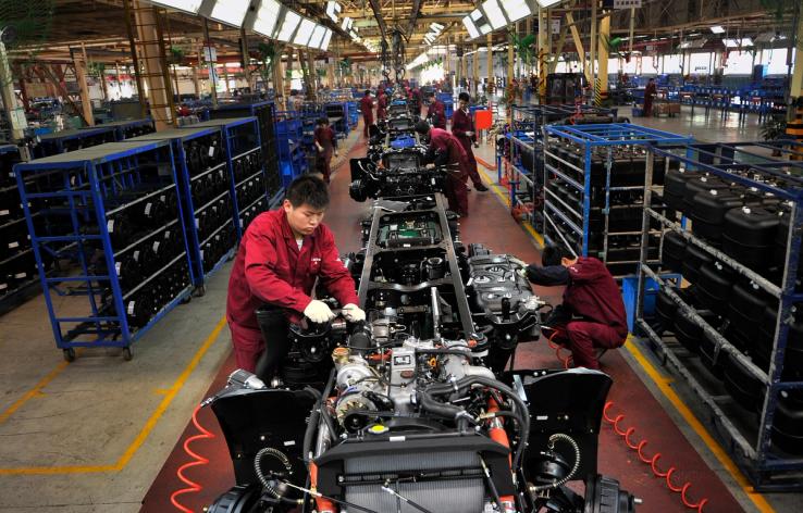 Workers install the chassis along a production line at a truck factory of Anhui Jianghuai Automobile Co. Ltd (JAC Motors) in Hefei, Anhui province May 5, 2014.