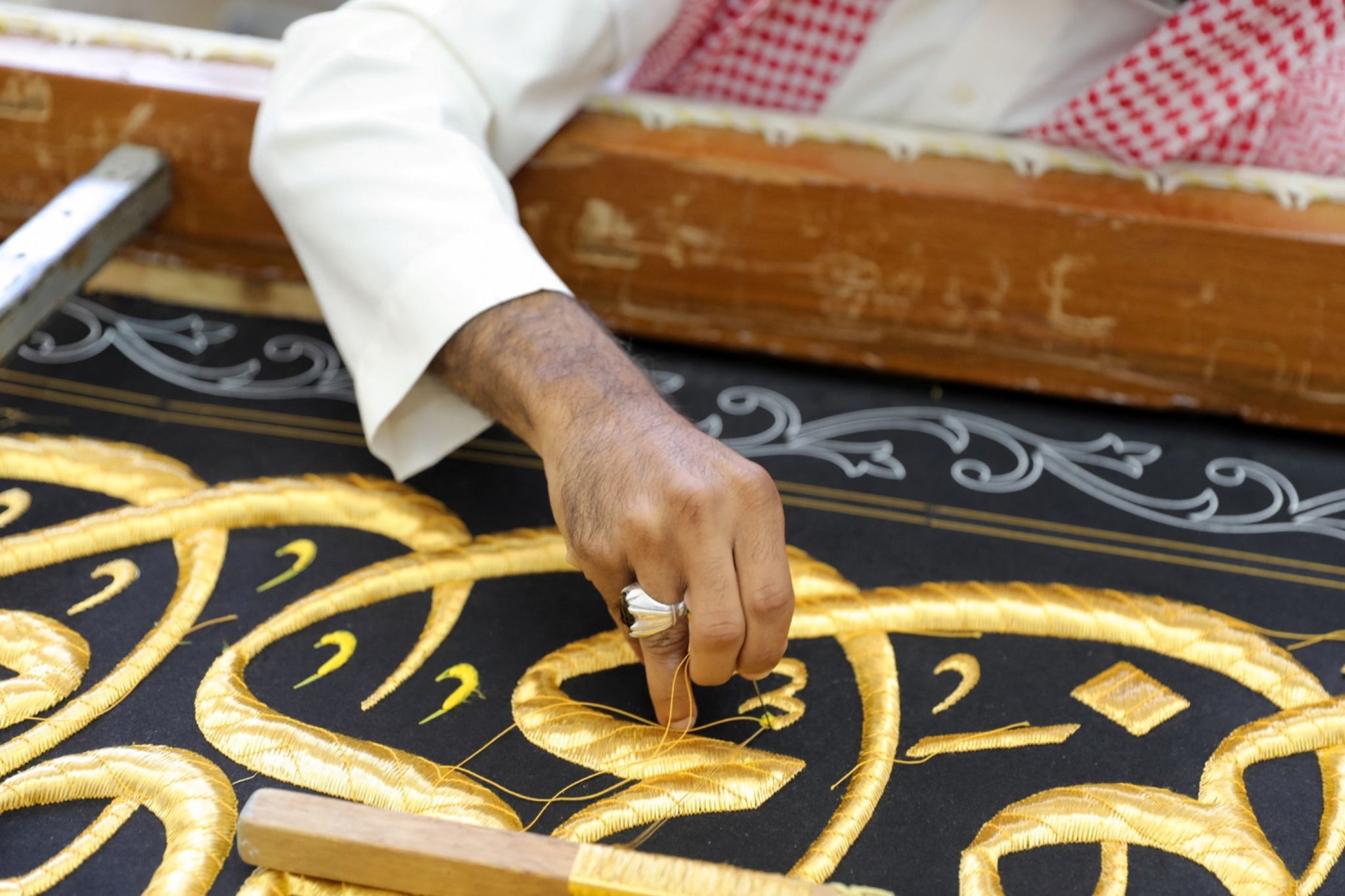 A worker prepares the Kiswa, the silk cloth that covers the Kaaba.