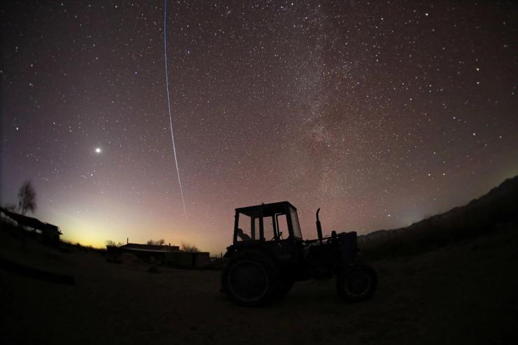 A satellite flying over the night sky.
